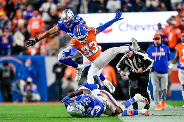 DENVER, CO - OCTOBER 15: Denver Broncos cornerback Jahdae Barron (23) and Seattle Seahawks tight end AJ Barner (88) fly through the air after a tackle of running back Emanuel Wilson (23) during a game between the Seattle Seahawks and the Denver Broncos at Empower Field at Mile High on October 15, 2026 in Denver, Colorado. (Photo by Dustin Bradford Icon Sportswire) NFL, American Football Herren, USA OCT 15 Seahawks at Broncos EDITORIAL USE ONLY Icon132261015022