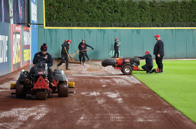 The groundskeeping crew attempts to dry off the warning track in the outfield after heavy rains fell before the start of game four of the MLB, Baseball Herren, USA American League Championship Series between the Tampa Bay Rays and the Cleveland Guardians at Progressive Field in Cleveland, Ohio, on Friday, October 16, 2026. The 8pm ET start of the game has been delayed due to the weather.  CLE20261016707 AARONxJOSEFCZYK