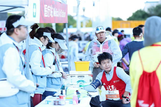 (261018) -- BEIJING, Oct. 18, 2026 -- A runners checks his blood pressure at a medical aid station before the 2026 Beijing Marathon & National Marathon Championships in Beijing, capital of China, Oct. 18, 2026. ) (SP)CHINA-BEIJING-2026 BEIJING MARATHON(CN) LixMing 