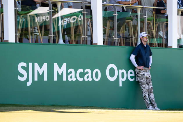 October 18, 2026, Macau, Macao Sar, China: Charles PORTER from the USA takes the tied lead on -14 Par with a stunning -9 Par final round. PORTER and his caddy hide from the heat in the shade of the hospitality stand on the 18th green. Macau Open Golf 2026 Final Round. Macau Open Golf 2026 Final Round  - ZUMAr144 20261018_zap_r144_045 Copyright: xJaynexRussellx