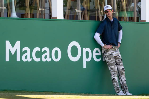October 18, 2026, Macau, Macao Sar, China: Charles PORTER from the USA takes the tied lead on -14 Par with a stunning -9 Par final round. PORTER and his caddy hide from the heat in the shade of the hospitality stand on the 18th green. Macau Open Golf 2026 Final Round. Macau Open Golf 2026 Final Round  - ZUMAr144 20261018_zap_r144_046 Copyright: xJaynexRussellx