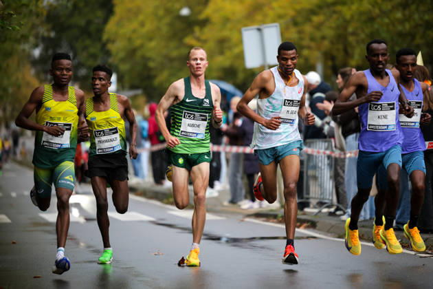 RECORD DATE NOT STATED 18th October 2026; Amsterdam, Netherlands; TCS Amsterdam Marathon; George Kusche of South Africa (centre) runs alongside Mayko Geay of Tanzania and Getachew Kene of Ethiopia (right) in a group of runners along Beethovenstraat AnthonyxBenoit