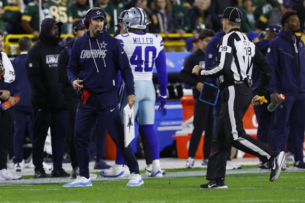GREEN BAY, WI - OCTOBER 18: Dallas Cowboys head coach Brian Schottenheimer reaches for his challenge flag during a game between the Green Bay Packers and the Dallas Cowboys on October 18, 2026 at Lambeau Field in Green Bay, WI. (Photo by Larry Radloff Icon Sportswire) NFL, American Football Herren, USA OCT 18 Cowboys at Packers EDITORIAL USE ONLY Icon2610181652