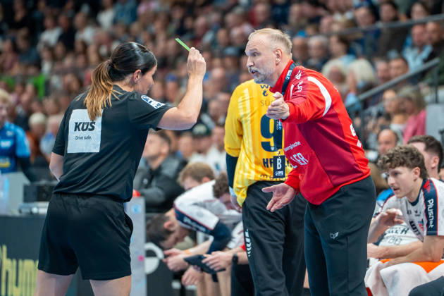 Handball I Herren I Saison 2026-2027 I Bundesliga I 10. Spieltag I TVB Stuttgart - SG BBM Bietigheim I 22.10.2026 Hartmut Mayerhoffer (Trainer, SG BBM Bietigheim) erhält eine Gelbe Karte von Schiedsrichter Gespann Kuttler Merz Stuttgart Porsche Arena Baden-Württemberg Deutschland Copyright: xLobeca MaxxPetershansx