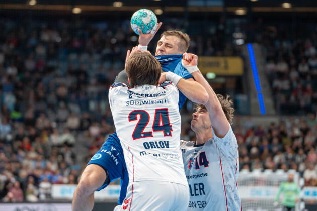 Handball I Herren I Saison 2026-2027 I Bundesliga I 10. Spieltag I TVB Stuttgart - SG BBM Bietigheim I 22.10.2026 Simone Mengon (15, TVB Stuttgart) mit Ball verteidigt von Maxim Orlov (24, SG BBM Bietigheim) und Fynn-Luca Nicolaus (14, SG BBM Bietigheim) Stuttgart Porsche Arena Baden-Württemberg Deutschland Copyright: xLobeca MaxxPetershansx