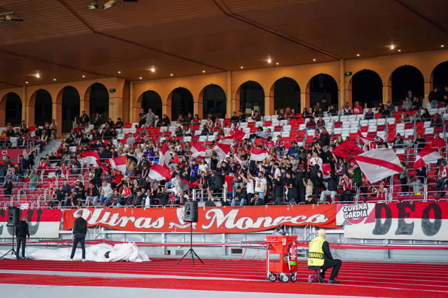 Fussball UEFA Conference League 2026 - 2027, 2. Spieltag - AS Monaco vs SC Freiburg - Stadion Louis II (Monaco): Fans und Anhänger der AS Monaco auf der Stadiontribüne beim Schwenken zahlreicher rot-weisser Vereinsfahnen. Im Vordergrund grosse Fanbanner der Ultras Monaco und der Fangruppierung Züvena Gardia. Heimfans, Fankultur, Ultras, Fanszene, Fanblock, Supporters, Stimmung, Anfeuerung, Fahnenmeer, Fanbanner, Transparent, Vereinsfarben, Zuschauer, Tribüne, Fanaktion, Fussball, Europapokal, Stadion, Totale. Copyright: xJOERANxSTEINSIEKx