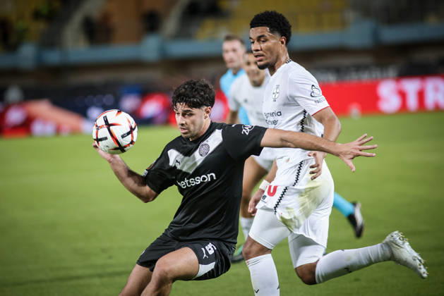 UEFA Europa League - OFI Crete vs Leverkusen - Zisis Karachalios of OFI Crete in action against Malik Tillman of Leverkusen during the UEFA Europa League phase Matchday 3 soccer match between OFI Crete vs Leverkusen in Pankritio, Heraklion, Greece, on 22 October 2026. IMAGO ONE INCH PRODUCTIONS Heraklion Greece Copyright: xONExINCHxPRODUCTIONSx 7133196