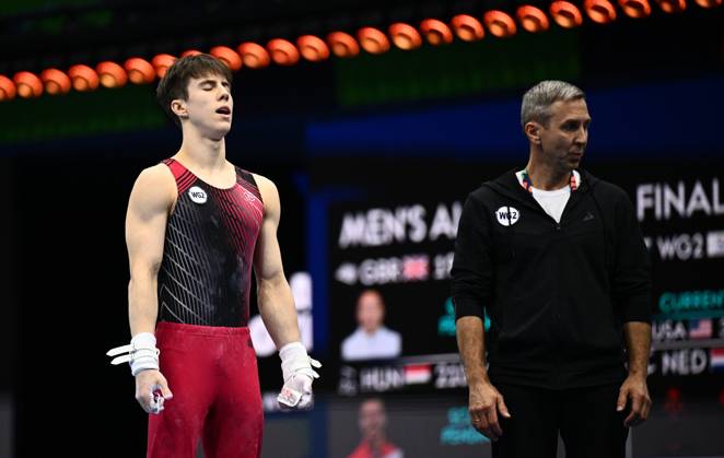 Netherlands Artistic Gymnastics World Championships 9271035 22.10.2026 Arsenii Dukhno of Team World Gymnastics Neutral Athletes 2 prepares to compete on the horizontal bar as his father and coach, Andrei Dukhno, stands nearby during the men s all-around final at the 2026 World Artistic Gymnastics Championships in Rotterdam, the Netherlands. Alexey Filippov Sputnik Rotterdam Netherlands  Copyright: xAlexeyxFilippovx