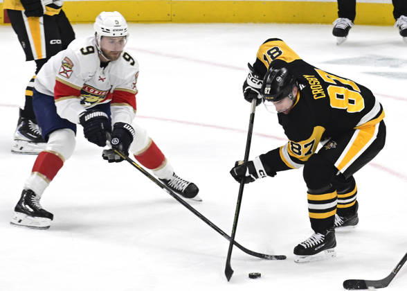 Pittsburgh Penguins center Sidney Crosby (87) plays the puck away from Florida Panthers center Sam Bennett (9) in the first period at PPG Paints Arena in Pittsburgh on Thursday, October 22, 2026.  PIT2026102204 ARCHIExCARPENTER
