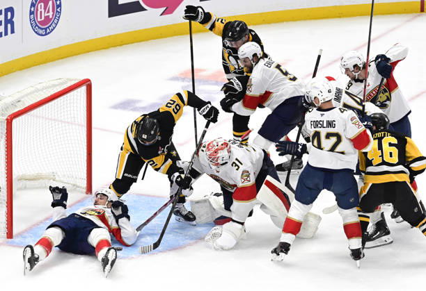 Pittsburgh Penguins left wing Andrei Kuzmenko (62) and Penguins center Hendrix Lapierre reaches for the puck as Florida Panthers right wing Garnet Hathaway (21) protects the goal with his body during the second period at PPG Paints Arena in Pittsburgh on Thursday, October 22, 2026.  PIT2026102209 ARCHIExCARPENTER