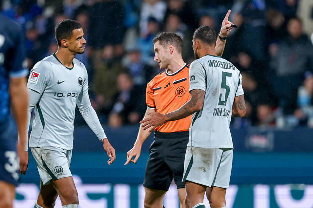 23.10.2026, Fußball, VfL Bochum - VfL Wolfsburg, 2. Fußball-Bundesliga, 9. Spieltag, Vonovia Ruhrstadion, Saison 2026 27: Schiedsrichter Eric Weisbach gestikulierend auf dem Spielfeld neben Vini Souza (VfL Wolfsburg 05) DFB regulations prohibit any use of photographs as image sequences and or quasi-video. Nordrhein-Westfalen Deutschland