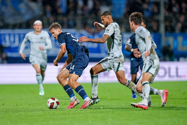 23.10.2026, Fußball, VfL Bochum - VfL Wolfsburg, 2. Fußball-Bundesliga, 9. Spieltag, Vonovia Ruhrstadion, Saison 2026 27: Tom Meyer (VfL Bochum 34) im Zweikampf gegen Vini Souza (VfL Wolfsburg 05) Joakim Maehle (VfL Wolfsburg 21) DFB regulations prohibit any use of photographs as image sequences and or quasi-video. Nordrhein-Westfalen Deutschland