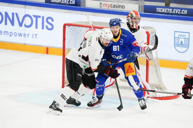 23.10.2026. Zug Schweiz. Eishockey Herren Saison 2026-2027 EV Zug - HC Lausanne. Bild. Dominik Kubalik EV Zug gegen Fabian Heldner HC Lausanne hinten Torhueter Ewan Huet HC Lausanne hinten Aktion Zweikampf