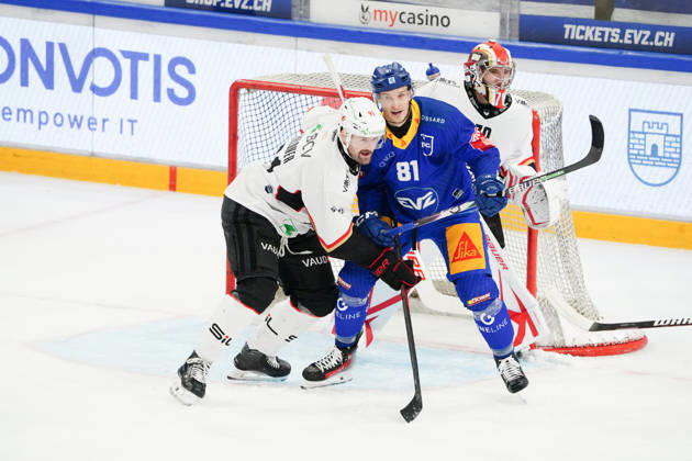 23.10.2026. Zug Schweiz. Eishockey Herren Saison 2026-2027 EV Zug - HC Lausanne. Bild. Dominik Kubalik EV Zug gegen Fabian Heldner HC Lausanne hinten Torhueter Ewan Huet HC Lausanne hinten Aktion Zweikampf