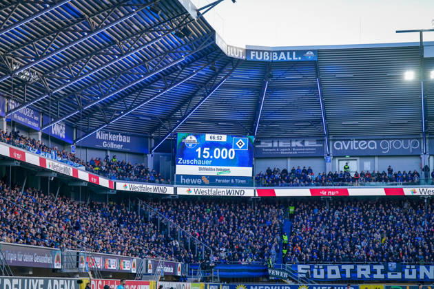 Deutschland: Fussball Bundesliga 2026 - 2027, 7. Spieltag - SC Paderborn vs Hamburger SV - Home-Deluxe-Arena (Paderborn): Anzeigetafel der Home-Deluxe-Arena in Paderborn mit der Zuschauerzahl von 15.000 beim Bundesligaspiel SC Paderborn 07 gegen Hamburger SV (HSV). Ausverkauftes Stadion, Stadionanzeige, Zuschauerrekord, Zuschauerzahl, Fans, volle Tribüne, Fankurve, Fanblock, Ultras, Fahnen, Banner PATRICUM, Fussball, Bundesliga, Sportstätte, Innenansicht, Totale, Stadiondach, Flutlicht, Werbung, Sponsoren, WestfalenWIND, hewe, avitea group, Klinkerbau Göllner. Copyright: xJOERANxSTEINSIEKx