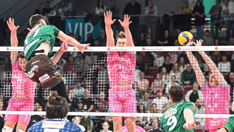 v.li.: Stijn van Schie (WWK Volleys München, 16) schmettert den Ball gegen den Block von Robert Viiber (Powervolleys Düren, 16) und Robin Baghdady (Powervolleys Düren, 8),, 24.10.2026, Düren (Deutschland), Volleyball, 1. Bundesliga Männer, Hauptrunde, SWD Powervolleys Düren - WWK Volleys München