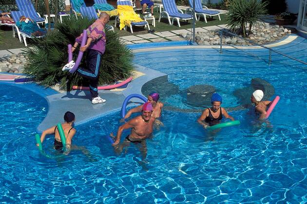 Kurgäste mit Animateur im Swimmingpool in einer Hotelanlage in Abano Terme