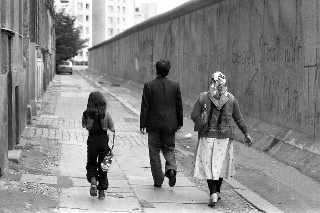 Türkische Familie geht entlang der Berliner Mauer spazieren
