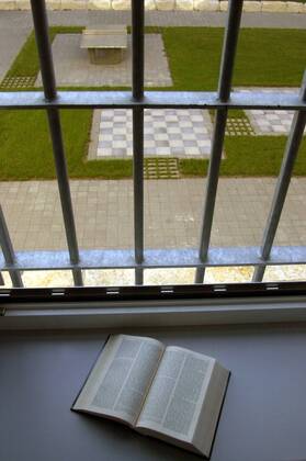 Aufgeschlagenes Buch vor Fenstergittern der Justizvollzugsanstalt Kempten