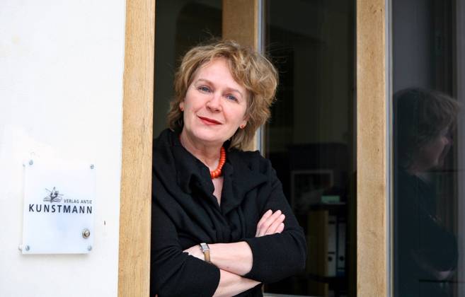 Verlegerin Antje Kunstmann (GER Verlag Antje Kunstmann GmbH) neben dem Firmenschild an der Tür des Verlages in München