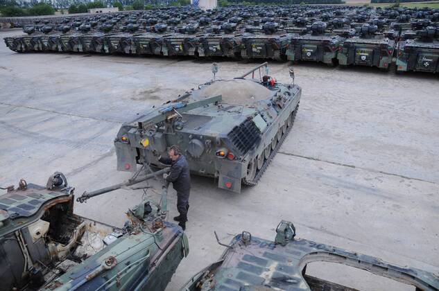 Mitarbeiter vor zu verschrottenden Panzern in der Battle Tank Dismantling GmbH i