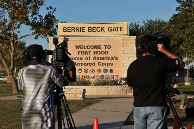 Two cameramen shoot footage outside the gate of the Fort Hood military base in Texas, the United States, on Nov. 6, 2009. Journalists from all over the world poured into the military base to cover the shooting after a military psychiatrist opened fire on his fellow soldiers in the Fort Hood military base on Thursday afternoon, leaving 13 dead and 30 others injured. (Xinhua Chen Ruwei) (wjd) (5)U.S.-FORT HOOD-SHOOTING-MEDIA 