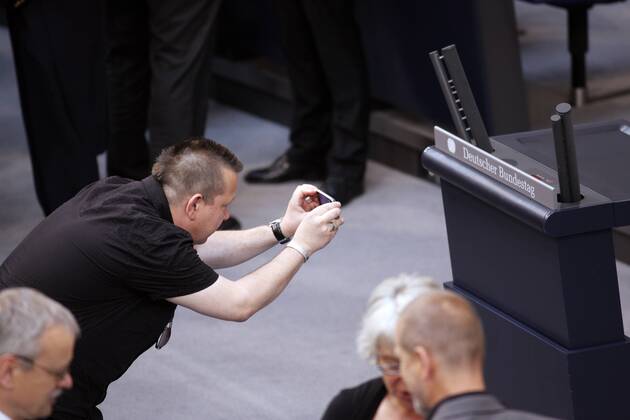 Berlin, den 30.06.2010 - Deutscher Bundestag 14. Bundesversammlung zur Wahl des Bundespräsidenten Foto: Sebastian Krumbiegel von der Gruppe Die Prinzen und nominiert als Wahlmann, fotografiert das Rednerpult mit dem Schriftzug Deutscher Bundestag im Plenarsaal.