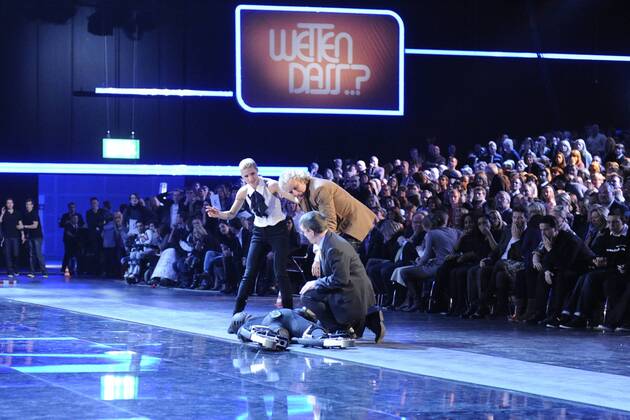 Wettkandidat Samuel KOCH während seiner Wettaktion, Wette Autos, springt mit Sprungfedern über fahrende Autos, wobei er sich schliesslich verletzt, bleibt verletzt am Boden liegen, Moderator Thomas GOTTSCHALK und Moderatorin Michelle HUNZIKER beugen sich über den Verletzten, Wetten dass...? aus Düsseldorf, 04.12.2010.