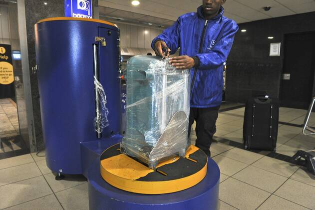 Baggage wrapped at airport to help prevent baggage theft - JOHANNESBURG, SOUTH AFRICA ? AUGUST 17: Baggage is wrapped at the OR Tambo International Airport on August 17, 2011 in Johannesburg, South Africa due to baggage theft. The situation which is getting out of control is prompting travellers to use alternatives to South African Airways. Gallo0000145032