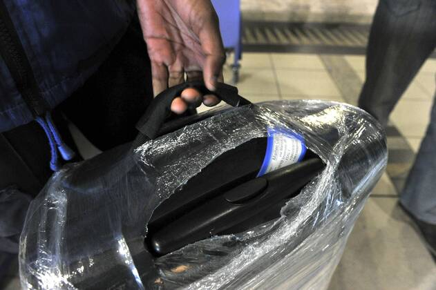 Baggage wrapped at airport to help prevent baggage theft - JOHANNESBURG, SOUTH AFRICA ? AUGUST 17: Baggage is wrapped at the OR Tambo International Airport on August 17, 2011 in Johannesburg, South Africa due to baggage theft. The situation which is getting out of control is prompting travellers to use alternatives to South African Airways. Gallo20114232