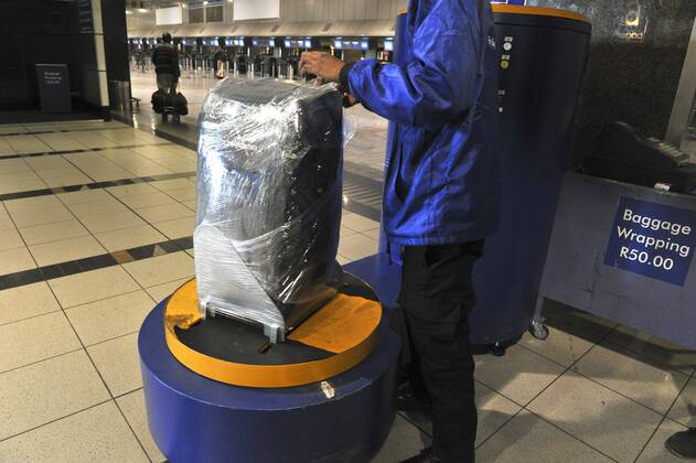 Baggage wrapped at airport to help prevent baggage theft - JOHANNESBURG, SOUTH AFRICA ? AUGUST 17: Baggage is wrapped at the OR Tambo International Airport on August 17, 2011 in Johannesburg, South Africa due to baggage theft. The situation which is getting out of control is prompting travellers to use alternatives to South African Airways. Gallo20114233