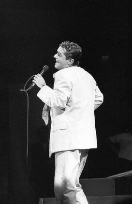 Falco (Sänger, Musiker) 10 86 dar Falco bei einem Konzert im Oktober 1986 Mann Gesang Musik Pop Rock Künstler Österreicher Österreich österreichisch österreichischer Johann Hölzel Bühne Auftritt Show seitlich singend Mikro Mikrofon in der Hand haltend seriös Anzug Hose Sakko Jackett Krawatte Gelfrisur zurückgekämmt dunkelhaarig halb Singer Music Musician Performance Stage hoch sw