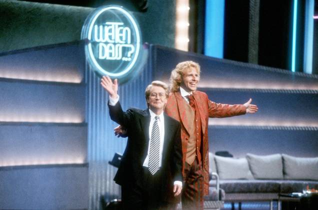 Wetten, daß...? (ZDF) 100. Aus- Gabe mit Thomas Gottschalk und Frank Elstner (li.) 03 96 mapo Fernsehen TV Show Moderation Mann seriös Jackett Krawatte quer halb stehend gestikulierend 30.03.96 in Düsseldorf Ausgabe Studio Dekoration Kulisse Logo