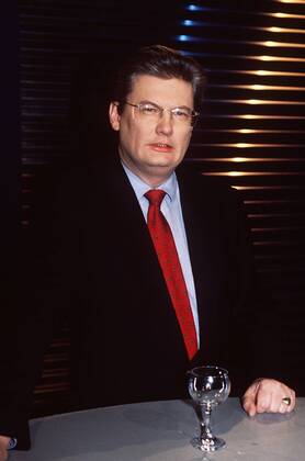 Sigmund Gottlieb (Journalist) 01 98 pu Mann Journalismus TV Fernsehen Moderation dunkelhaarig seriös Hemd Jackett Krawatte stehend Tisch Glas Studio Dekoration Kulisse halb hoch neutral Brille