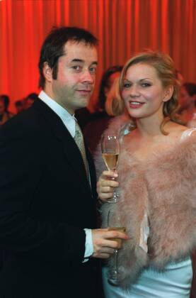Jan Josef Liefers und Anna Loos 12 01 urb Schauspieler Schauspielerin Schauspiel TV Fernsehen festlich stehend Saal Halle dunkel halb hoch lächelnd sich umschauend angelehnt Glas Getränk Sekt Aids-Gala am 02.12.2001 in Berlin Farbnegativ
