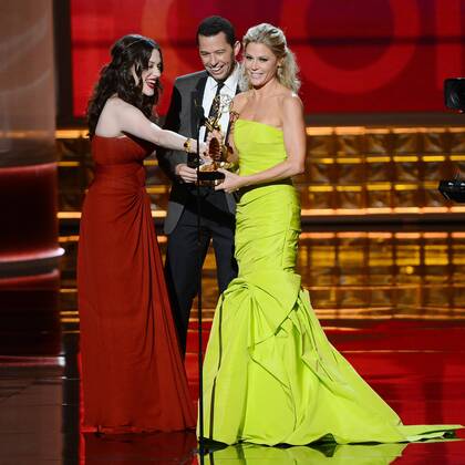 Actress Kat Dennings (L) and actor Jon Cryer present the Emmy Award to actress Julie Bowen onstage at the 64th Primetime Emmys at the Nokia Theatre in Los Angeles on September 23, 2012.  LAP20120923124