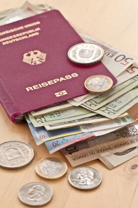 Deutscher Reisepass mit verschiedenen Währungen 1079700624