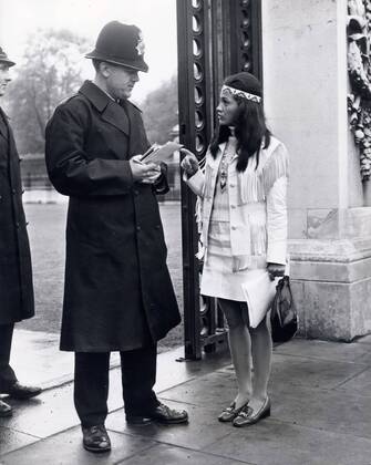 May 22, 1969 - London, England, United Kingdom - KAHN TINETA HORN talks to a policemen at the gates of Buckingham Palace to whom she gave notes to in her effort to gain an appointment with the Queen.. London United Kingdom - ZUMAk09