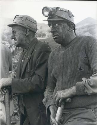 Oct. 22, 1966 - 71 dead and 58 entombed in Avalanche at Aberfan: At least 71 people, mostly children, are dead and between 58 and 60 still entombed at Aberfan, near Marthyr Tydfil, South Wales, after a rain-soaked coal tip avalanched on an infants school, a farm and a row of houses. Eighty five children are safe and 36 are in hospital. Photo shows two of the grim faced rescue workers at the scene of the disaster in Aberfan.  - ZUMAk09