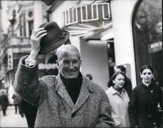 Feb. 02, 1968 - Maurice Chevalier here for farewell concert tour he joins the Queue to see the film Camelot : Maurice Chevalier, the most durable entertainer, and the most popular Frenchman in the world, has arrived in London. Now nearly 80, he is here to make a farewell tour of Britain doing a series of one-man concerts, all one-night stands, starting in Manchester on Feb 13th, and coming to the London Palladium on Sunday Feb 18th. This afternoon Maurice went along to the Warner Cinema to see the film Camelot . Photo shows Maurice Chevalier doffs his hat as he walks through Leicester Square on his way to see the film Camelot at the Warner Cinema this afternoon. - ZUMAk09