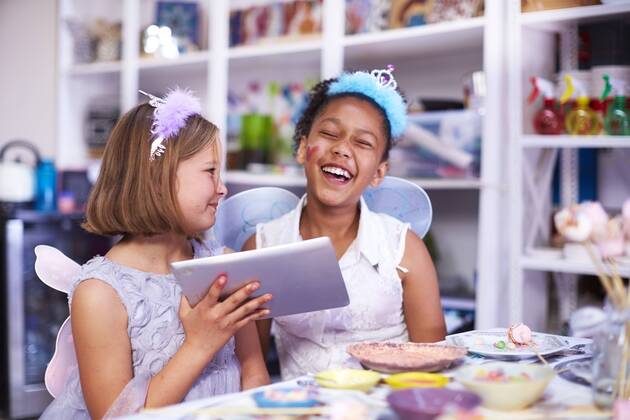 Two girls using digital tablet on a birthday party model released Symbolfoto property released  ZEF001373