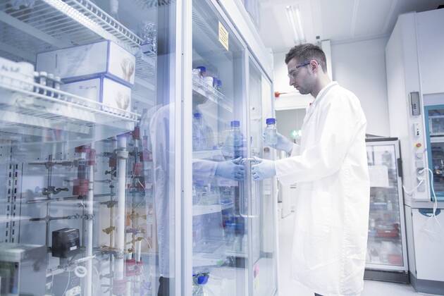 Scientist in microbiological lab opening fridge model released Symbolfoto property released  SGF001324