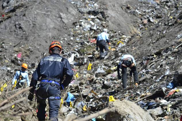 Handout pictures dated March 26, 2015 shows members of the French national gendarmerie investigating the area after the A320 Germanwings passenger aircraft crashed in a mountain range of the French Alps. The plane heading to Dusseldorf from Barcelona with 150 people onboard was allegedly taken down by its co-pilot Andreas Lubitz, there were no survivors.  PAR20150327202 FrancisxPellier