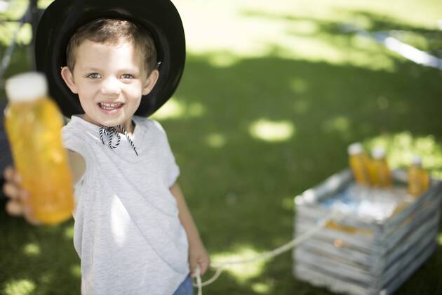 Boy in garden offering a cool drink model released Symbolfoto property released  ZEF003225