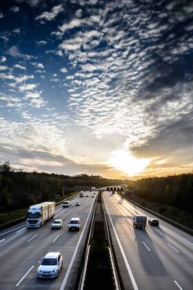 Autos und Lkw fahren auf der A2 bei Helmstedt (Niedersachsen) im Sonnenuntergang.