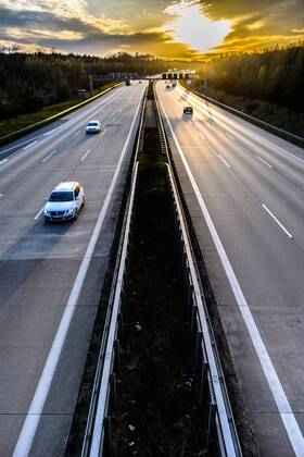 Autos und Lkw fahren auf der A2 bei Helmstedt (Niedersachsen) im Sonnenuntergang.