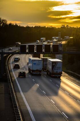 Autos und Lkw fahren auf der A2 bei Helmstedt (Niedersachsen) im Sonnenuntergang.