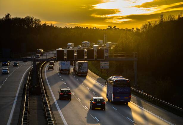 Autos und Lkw fahren auf der A2 bei Helmstedt (Niedersachsen) im Sonnenuntergang.