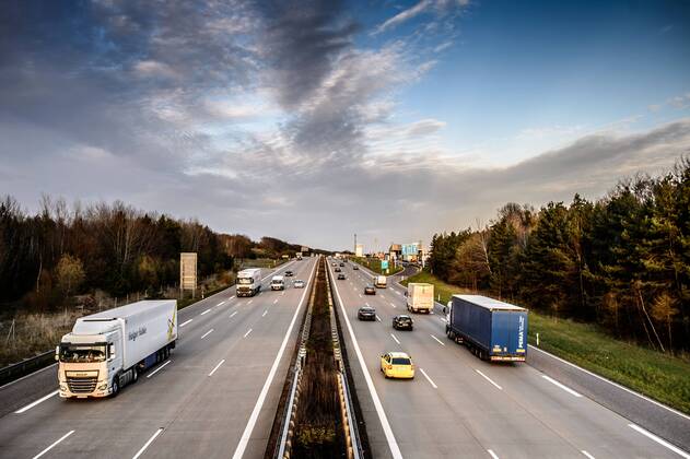 Autos und Lkw fahren auf der A2 bei Helmstedt (Niedersachsen) im Sonnenuntergang.