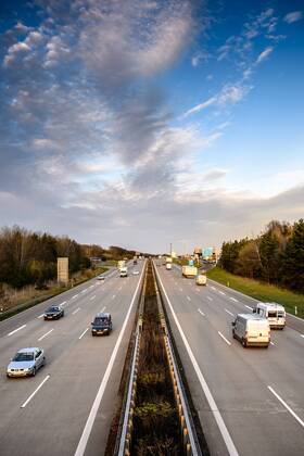 Autos und Lkw fahren auf der A2 bei Helmstedt (Niedersachsen) im Sonnenuntergang.